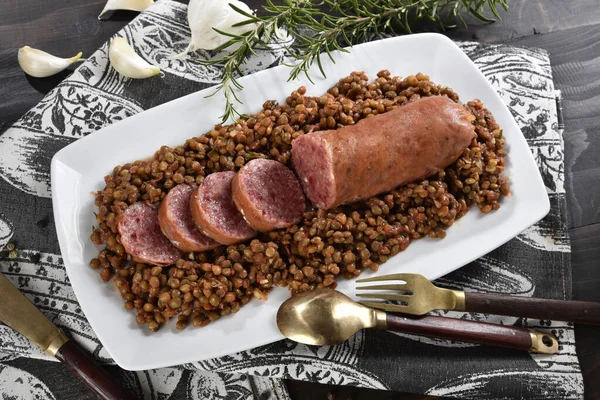 Cotechino served with lentils on a serving plate. Typical Modenese dish