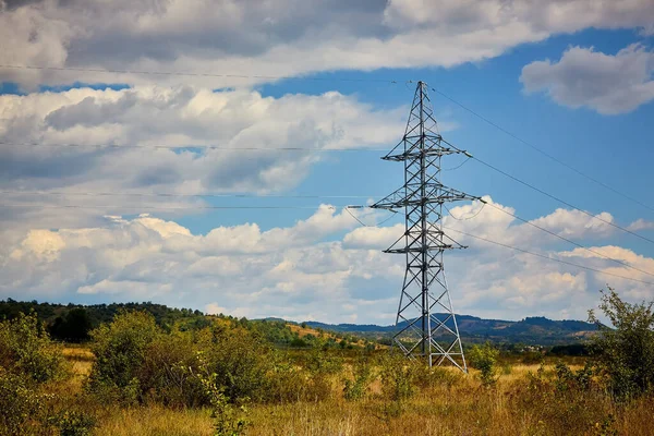 Metal pole of a power line against a cloudy sky