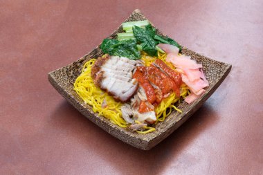 Tayland 'ın en iyi menüsü. Görüş açısı belirsiz. Erişte, domuz eti ve ördek rostosu. Dilimlenmiş zencefil ve hardal yeşiliyle. Hindistan cevizinden bir tabak. Eski bir fayans döşemesi düzenledim.. 