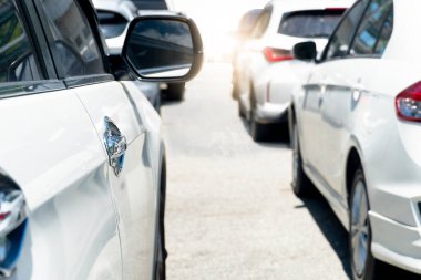 Trafik sıkışıklığı sırasında asfalt yollarda dizilmiş çok sayıda aracın yanı sıra. Güneşin parladığı gün boyunca açık hava atmosferi. İlerideki yola doğru gidiyor..
