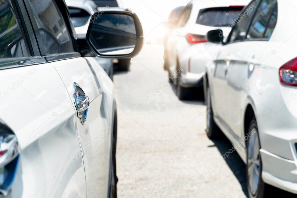 Beside of several vehicles line up on asphalt roads during traffic jams. Outdoor atmosphere during the day when the sun shines brightly. heading for the road ahead.