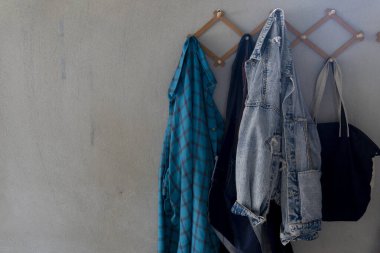 Çimento duvara asılan giysiler. Ev aletlerinin arkaplanı.