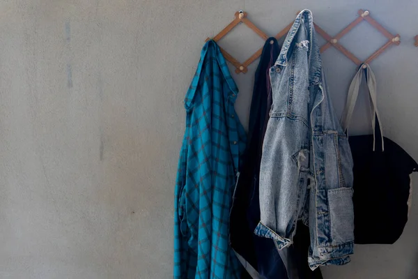 Çimento duvara asılan giysiler. Ev aletlerinin arkaplanı.