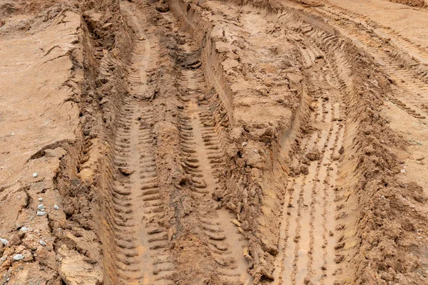 Road ahead liquid mud off road and there are marks of tires.