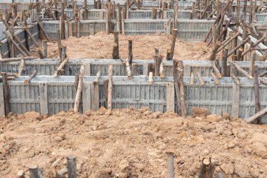 Block formwork for house beams with supported by wooden logs. Construction of the foundation of the house on the ground during the day time.