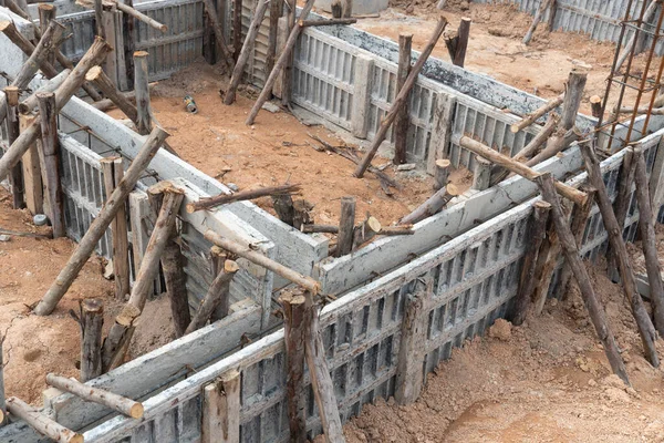Block formwork for house beams with supported by wooden logs. Construction of the foundation of the house on the ground during the day time.