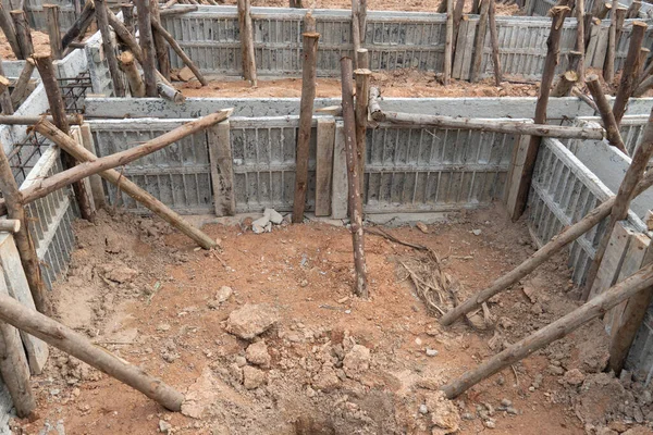 Block formwork for house beams with supported by wooden logs. Construction of the foundation of the house on the ground during the day time.