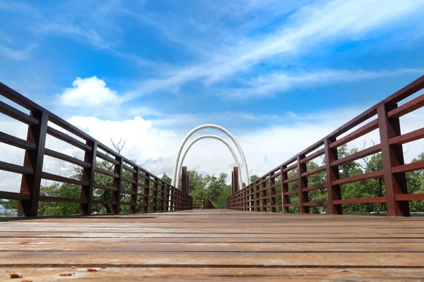 Wooden bridge over the river. Looking from the bridge to the other side and seeing the mangrove trees under the blue sky. At Phra Chedi Klang Nam, Pak Nam, Rayong, Thailand.