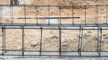 Ev kiriş yapıları için kablolar. Çimento dolu bir yere, siyah bir çevreye yerleştir. Gündüz vakti evin temelinin atılması..