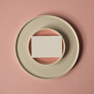 Fotokopi alanı olan boş kağıt kağıdı. Minimal ticari marka şablonu. Tozlu pembe arka planda seramik plakalar. Düz yatış, üst görünüm