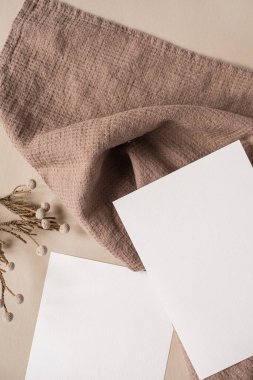 Estetik Parisli stil markalaştırma şablonu. Sahte kopya alanı olan boş kağıt kağıtlar, kuru çiçek dalları ve tarafsız bej arka planda kumaş. Düz yatış, üst görünüm