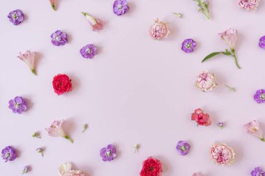 Renkli çiçekli estetik bir arka plan. Güzel çiçek şablonu kompozisyonu. Boş kopya alanı olan yuvarlak çelenk çerçevesi arkaplan oluşturur. Düz yatış, üst görünüm