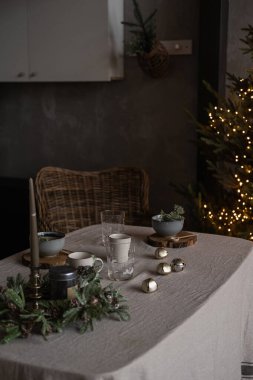 Modern ev dekorasyonu konsepti. Noel ağacıyla süslenmiş rahat bir oturma odası. Hediyeler, masa, rattan sandalye. Noel, Yeni Yıl kutlamaları.
