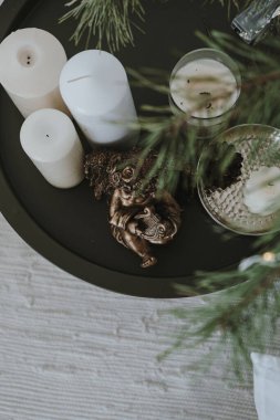 Spruce manzarası, köknar iğnesi dalları, yuvarlak masadaki mumlar. Minimum dekore edilmiş iç tasarım. Düz yatıyordu