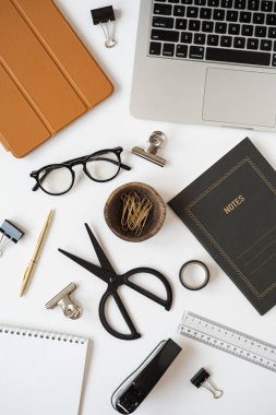 Estetik ofis masası çalışma alanı dizüstü bilgisayarı, not defteri, masa örtüsü, beyaz arka planda kırtasiye malzemeleri. Düzleştirme, üst görünüm blogu, web sitesi, sosyal medya kavramı