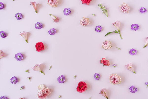 Frame made of rose flower buds on pink background. Flatlay, top view. View from above. Copy space mockup.