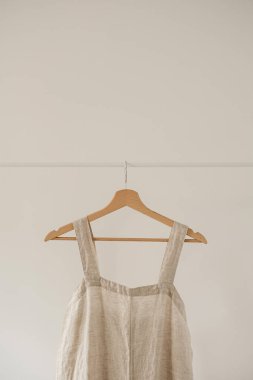 Tarafsız pastel bej rengi elbise ya da beyaz askıda yıkanmış keten kumaştan yapılmış kadın kıyafetleri konsepti. Moda blogu, web sitesi, sosyal medya