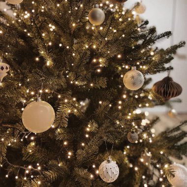 Parlayan çelenk ışıklarıyla süslenmiş minimalist Noel ağacı. Noel kompozisyonu