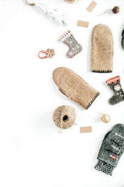 Estetik Noel süslemeleri. Gri ve bej kaplama sıcak kış eldivenleri, çoraplar, beyaz arka planda süslemeler. Düz yatar, üst görünüm Noel moda kompozisyonu