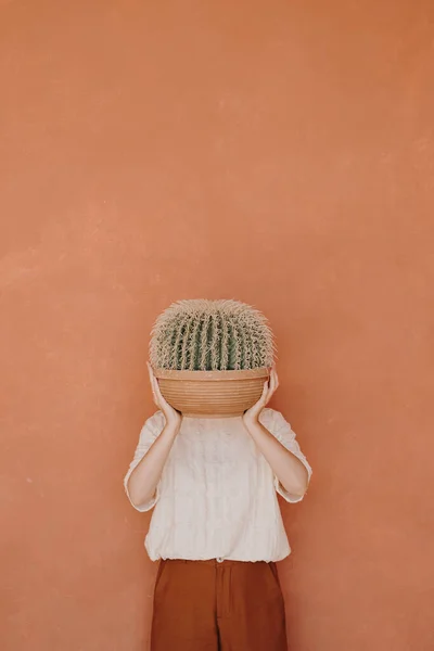 Vrouw Houden Huis Plant Cactus Tegen Perzik Gember Muur — Stockfoto