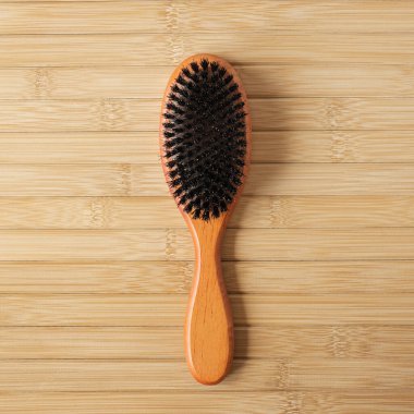 Tahta arka planda banyo masajı fırçası. Düz yatış, üst görünüm