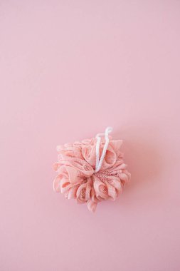 Spa, banyo, sağlık, pembe arka planda sünger olan cilt konsepti. En küçük üst görünüm, düz konum