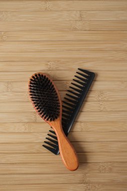 Masaj fırçası ve ahşap arka planda saç tarağı. Düz yatış, üst görünüm