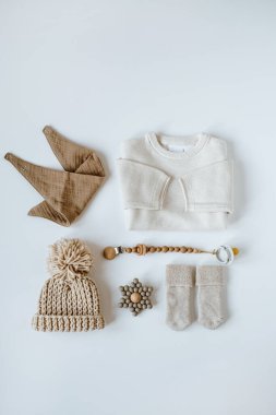 Sıcak çevre dostu stil İskandinav bebek kıyafetleri, aksesuar kolajı. Çevrimiçi moda mağazası, online alışveriş markası konsepti. Sıcak kazak, şapka, çorap, muslin önlük, tutacağı olan emzik.