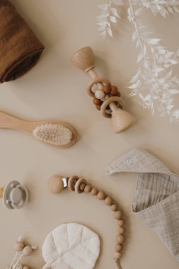 Pastel bej, rahat çevre dostu İskandinav bebek bakım aksesuarları. Çevrimiçi moda mağazası, online alışveriş markası konsepti. Muslin bib, fırça, emzik, nötr bej üzerine emzik tutucu