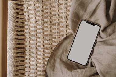 Flatlay cep telefonu, keten bankta nötr bej keten kumaş. Estetik zarif blog, çevrimiçi dükkan, mağaza, sosyal medya markalaşma şablonu