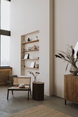 Estetik parlak, güneşli, zarif oturma odası iç tasarımı, rahat şezlonglu sandalye, şapka, yan masa, çiçek buketi, süslemeli raf. İskandinav iç tasarımı