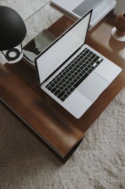 Estetik ofis çalışma masası. Boş ekran, lamba, koyu kahverengi kahve masasında çay mumu olan dizüstü bilgisayar. İş, iş kavramı