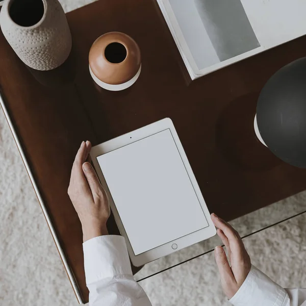 Aesthetic minimalist home office workspace desk. Person using tablet pad. Blank mockup screen template. Work, business concept. Online shopping, online store branding. Flat lay, top view, above