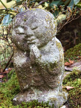 Kyoto, Japonya - 20 Kasım 2021: Japonya 'nın Kyoto kentindeki yosun kaplı bir bahçede çocukların küçük dölleme tanrısı veya koruyucu tanrısı