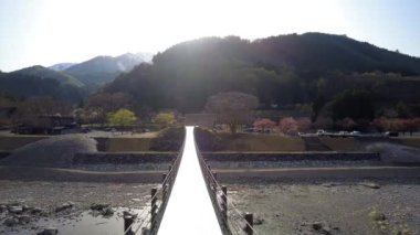 Gifu,Japan - April 22, 2022: Deai bridge on Sho river, a suspension bridge connecting the Bus Parking lot and the UNESCO town of Shirakawa-Go
