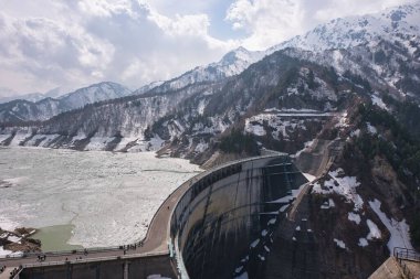 Toyama, Japonya - 23 Nisan 2022: Kısmen buzla kaplı Kurobe Gölü ve baharda Kurobe Barajı