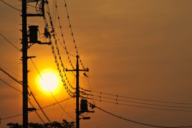 Tokyo, Japonya - 20 Mayıs 2022: Elektrik direklerinin silüeti ve gündoğumunda kablo 