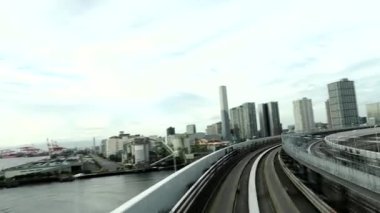 Tokyo, Japonya - 9 Ekim 2022: (3x hız) Tokyo Rıhtımı Yeni Transit Rıhtım Hattı Gökkuşağı Köprüsü 'nü geçmek için döngü üzerinde ilerliyor