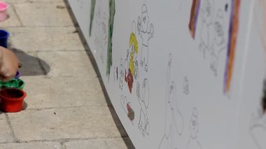 Küçük çocuklar renkli tebeşirle kaldırıma renkli resimler çizerler. Mutlu çocuklar renkli başyapıtlar çizerek yaratıcılığın tadını çıkarırlar.
