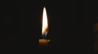 Candles burn in an Orthodox church. Burning candles that stand in a row. Church candles burn on a large gold candlestick in the church