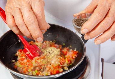 Soğan, domates, biber ve kişniş sosundan yapılan geleneksel Kolombiya usulü hogao ya da criollo sosu (salsa criolla) hazırlama