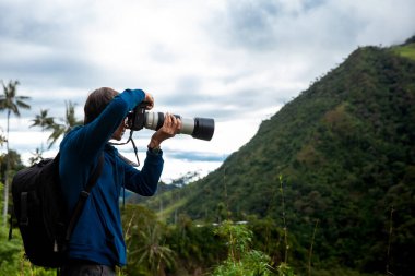Kolombiya 'nın Quindio bölgesindeki Salento' daki güzel Valle de Cocora 'da fotoğraf çeken bir turist.