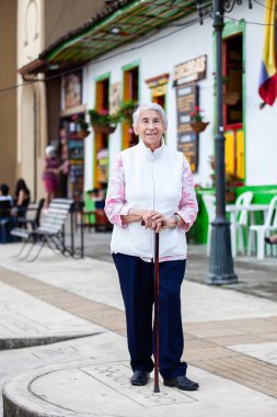 Senior woman at a traditional colorful street in the beautiful colonial town of Salento in the region of Quindio in Colombia