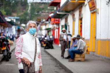 Senior woman at a traditional colorful street in the beautiful colonial town of Salento in the region of Quindio in Colombia