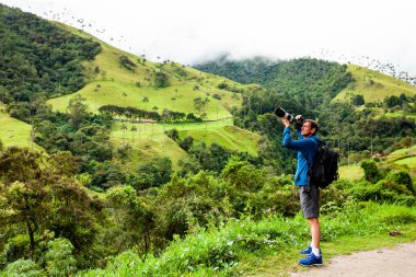 Kolombiya 'nın Quindio bölgesindeki Salento' daki güzel Valle de Cocora 'da fotoğraf çeken bir turist.