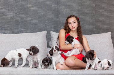 Küçük Fransız Braque köpeğiyle kırmızı giyinmiş güzel bir genç kız.