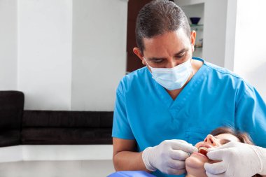 Kadın bir hastayı tedavi eden diş hekimi.