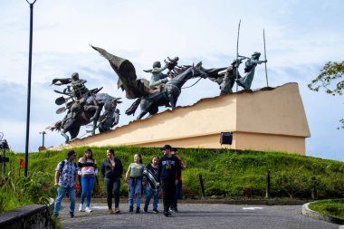 MANIZALES, COLOMBIA - MAY, 2022: Tourists at the Monument to the Colonizers created by the artist Luis Guillermo Vallejo with the sand bronze casting technique