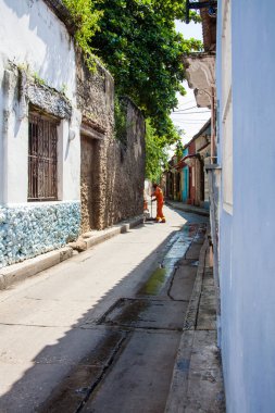 CARTAGENA DE INDIAS, COLOMBIA - AĞUSTOS 2011: Cartagena de Indias 'taki sömürge Getsemani mahallesinde sokakları turuncu üniformalı süpürücü