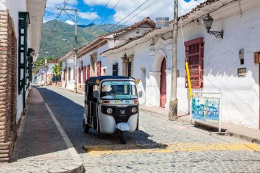 SANTA FE DE ANTIOQUIA, , COLOMBIA - NOVEMBER, 2017: Traditional public transport motorcycle  at the beautiful antique streets of the colonial town of Santa Fe de Antioquia in Colombia